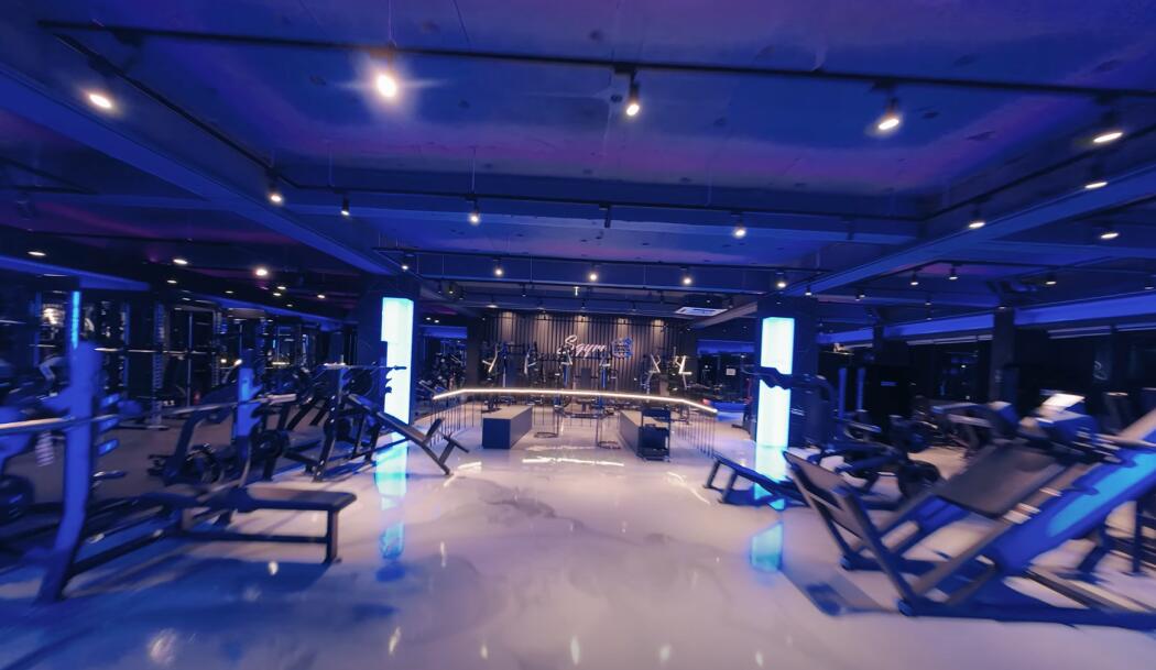 Gym floor lit in blue and violet, seen from an FPV drone